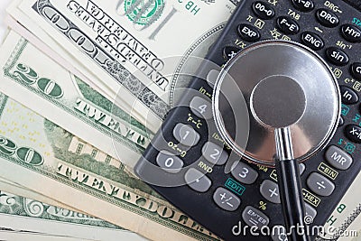Financial analysis, audit or accounting - Stethoscope over a calculator and dollar bills. Medical costs, financial concept Stock Photo