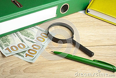 Financial and budget concept. Accounting books, money, magnifying glass and pen on office table Stock Photo