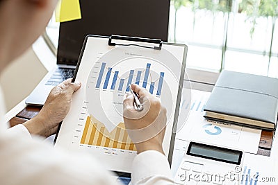 A financial businessman examines the financial information of the company. Stock Photo