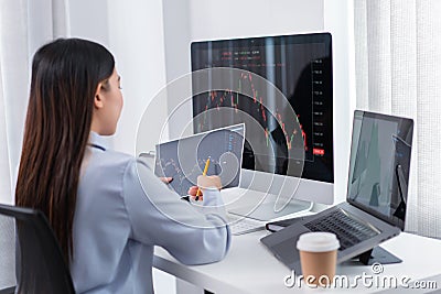 Financial concept a businesswoman studying the stock chart to decide to invest in which stock fund Stock Photo