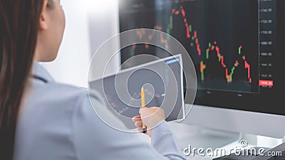 Financial concept a businesswoman studying the stock chart to decide to invest in which stock fund Stock Photo