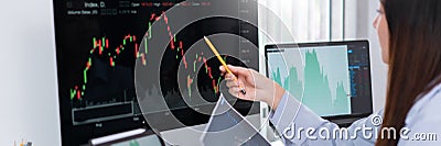 Financial concept a businesswoman studying the stock chart to decide to invest in which stock fund Stock Photo