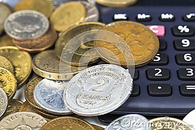 Financial concept. Calculator surrounded by various world currency coins closeup Stock Photo
