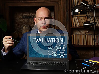 Financial concept meaning EVALUATION with sign on the laptop. Concept about a systematic determination of a subject`s merit, wort Stock Photo