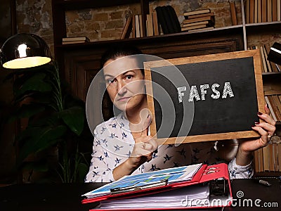 Financial concept meaning Free Application for Federal Student Aid FAFSA with phrase on black chalkboard in hand Stock Photo