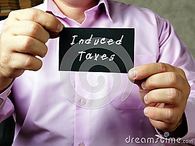Financial concept meaning Induced Taxes with phrase on the piece of paper Stock Photo