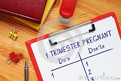 Financial concept about 1 TRIMESTER PREGNANT Do`s and Don`ts with phrase on the piece of paper Stock Photo