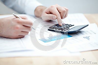 Financial data analyzing. Counting on calculator. Stock Photo