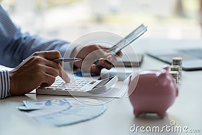 Financial planning at home in crisis. Man working. Home budget planning. Businessman holding pen and press calculator to calculate Stock Photo