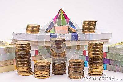 Financial pyramid, wads of money and stacks of coins Stock Photo