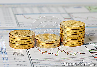 Financial settlement with the charts and golden coins. Stock Photo