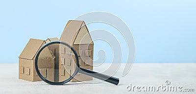 Finding or choosing the best home. Magnifying glass and cardboard miniature houses. Sale or rental of housing Stock Photo