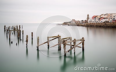 Fine art landscape image of derelict pier in milky long exposure Stock Photo