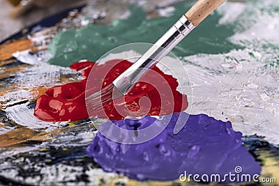 Fine art school. Closeup of artist hands holding wooden palette, mixing acrylic paint with brush Stock Photo