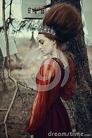 Young girl is posing in a red dress with creative hairstyle Stock Photo