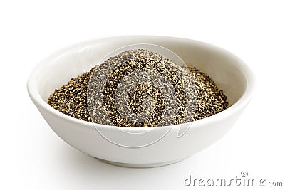 Finely ground black pepper in white ceramic bowl isolated on white. Stock Photo