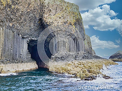 Fingal`s Cave surrounded by columns of jointed volcanic basalt rocks on the island of Staffa in Scotland Stock Photo