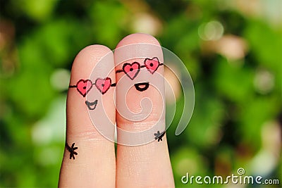 Finger art of a Happy couple. A man and a woman hug in pink glasses in shape of hearts. Stock Photo