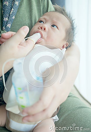 Finger Feeding breast milk to newborn baby boy using small tube Stock Photo