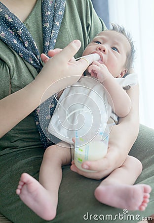 Finger Feeding breast milk to newborn baby boy using small tube Stock Photo