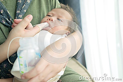 Finger Feeding breast milk to newborn baby boy using small tube Stock Photo