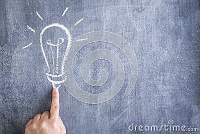 finger pointing light bulb drawn with chalk chalkboard Stock Photo