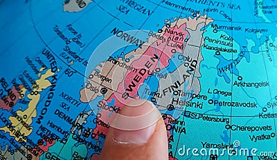 Finger pointing to the country of Sweden on a Globe Stock Photo
