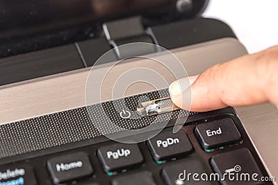 Finger press power off button on laptop Stock Photo