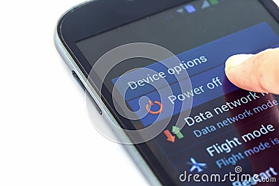 Finger press power off button on smartphone Stock Photo