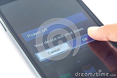 Finger press power off button on smartphone Stock Photo