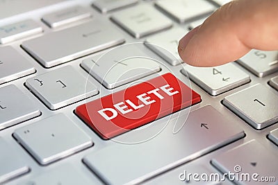 Finger presses the color button on the gray keyboard. A keyboard with a red button - Delete Stock Photo