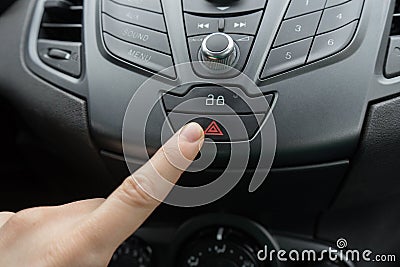 Finger pressing car emergency light button Stock Photo