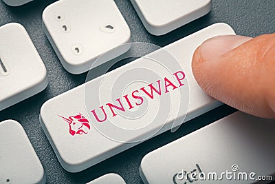 Finger pressing computer key with uniswap altcoin logo Editorial Stock Photo