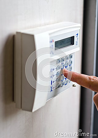 Finger pressing keys on alarm keypad Stock Photo