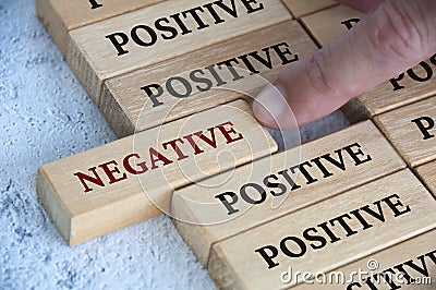 Finger pushing negative text on wooden block from the rest of the wooden blocks with positive text. Positive mindset Stock Photo