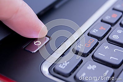 A finger is pushing the power button Stock Photo