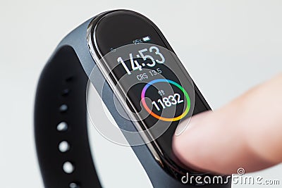 Finger touching screen of digital fitness tracker smart band Editorial Stock Photo