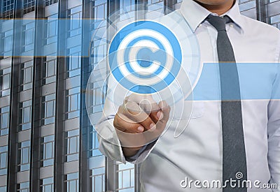 Finger of young businessman point to the blue Copyrighted icon. Stock Photo