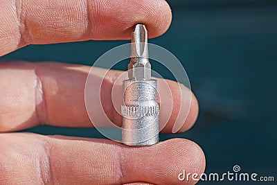 Fingers hold one gray metal adapter with a screwdriver Stock Photo