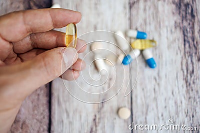 Fingers holding an omega capsule. nutritional supplements and vitamins Stock Photo