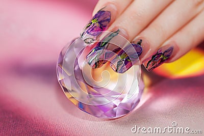Fingers with beautiful manicure touch a shining diamond Stock Photo