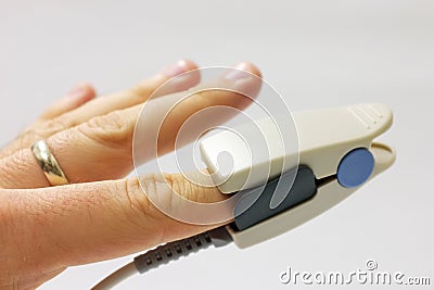 Fingertip pulse oximeter sensor placed on finger Stock Photo