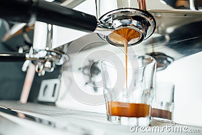 Finish of the espresso extraction process from bottomless portafilter in a glass cup Stock Photo