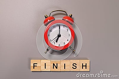 Finish word and alarm clock on gray background Stock Photo