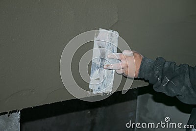 Building. Finishing work. Plasterer work. The hand of the master is rubbing the plaster solution Stock Photo