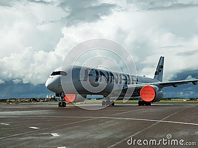 Finnair plane on the runway against the background of the cloudy sky. Vantaa, Finland. Editorial Stock Photo