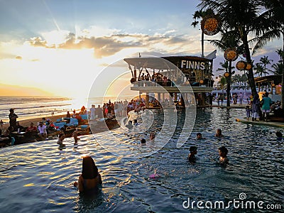 Finns Beach Club, A vacation destination in Bali with a lively beach party, a palm tree architecture, and a breathtaking sunset Editorial Stock Photo