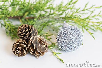 Fir branch, three pinecones and tinsel holiday decoration on white background Stock Photo