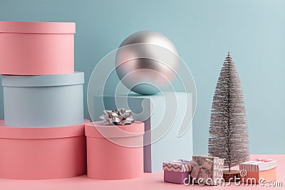 Fir tree, ball, round and square gift boxes on pink and teal background Stock Photo