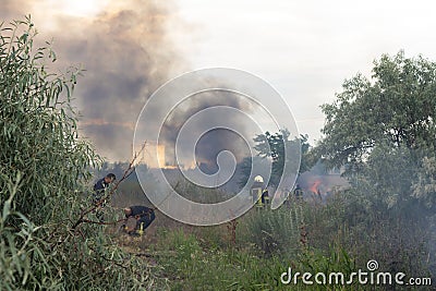 A fire brigade on a fire engine extinguishes a forest fire. Inscriptions on the car in Russian - fire truck and Odessa. 2019. 06. Editorial Stock Photo